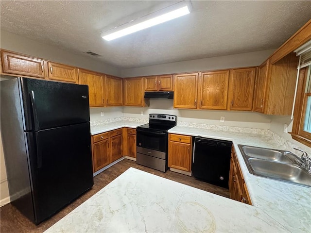 kitchen featuring a sink, black appliances, visible vents, under cabinet range hood, and light countertops