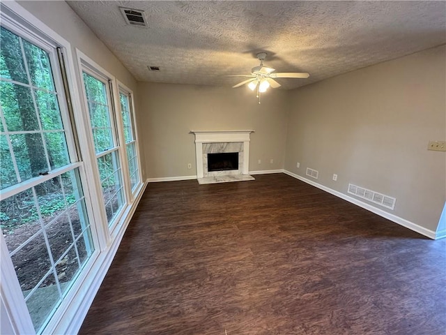 unfurnished living room featuring visible vents, baseboards, ceiling fan, and dark wood-style floors