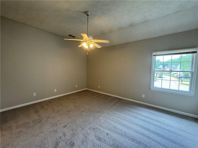 unfurnished room with carpet flooring, visible vents, baseboards, and a ceiling fan