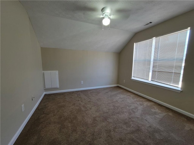 additional living space featuring visible vents, carpet flooring, vaulted ceiling, ceiling fan, and baseboards