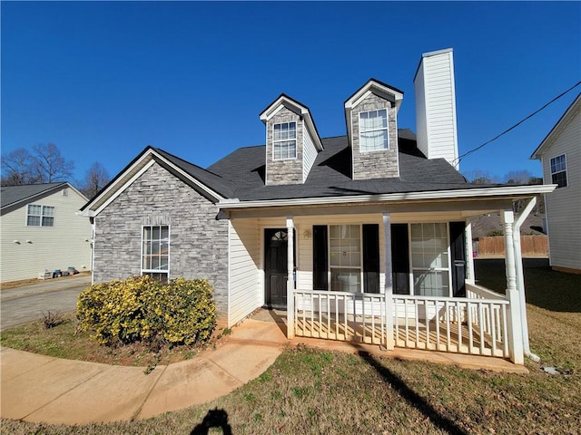 view of front facade featuring a porch and a chimney