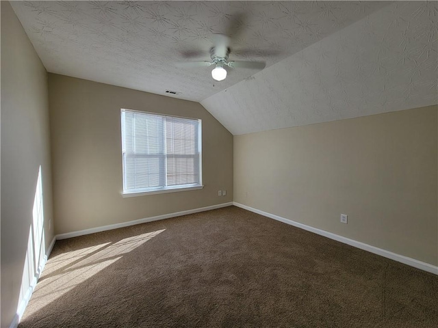 additional living space with baseboards, vaulted ceiling, a textured ceiling, and carpet flooring