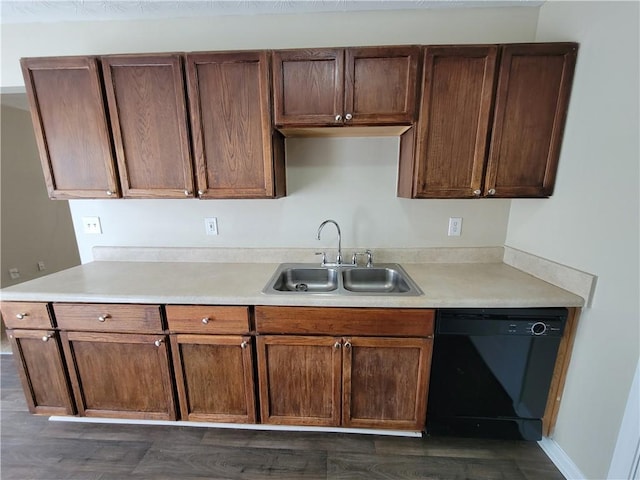 kitchen featuring black dishwasher, light countertops, and a sink