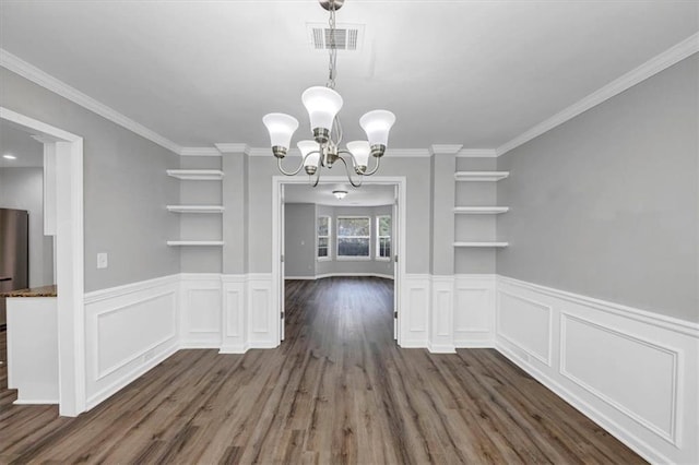 unfurnished dining area with dark hardwood / wood-style floors, crown molding, an inviting chandelier, and built in shelves