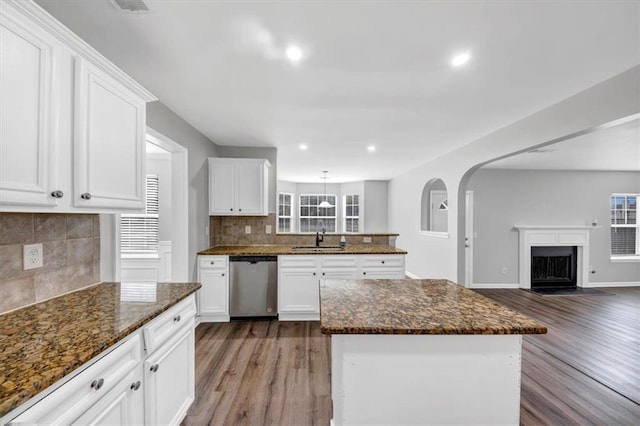 kitchen with dark stone counters, dark hardwood / wood-style floors, decorative backsplash, white cabinets, and dishwasher