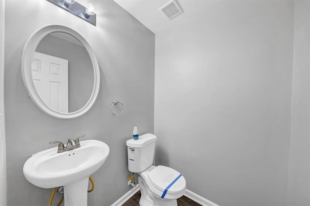 bathroom featuring hardwood / wood-style floors, toilet, and sink