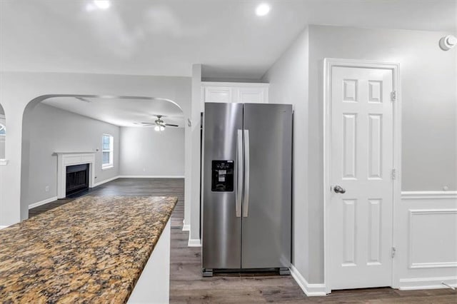 kitchen with dark hardwood / wood-style flooring, dark stone counters, white cabinets, ceiling fan, and stainless steel fridge