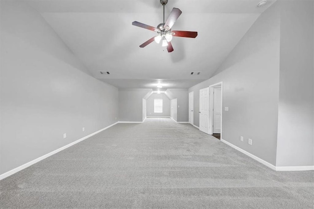 carpeted spare room with ceiling fan and vaulted ceiling