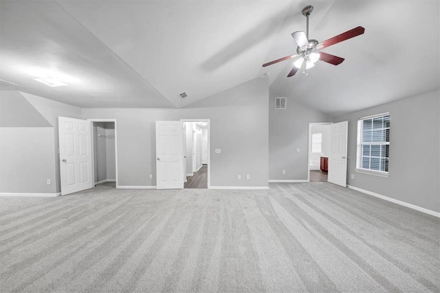 unfurnished bedroom featuring light carpet, ceiling fan, and vaulted ceiling