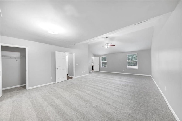 unfurnished bedroom with ceiling fan, light colored carpet, a closet, and lofted ceiling