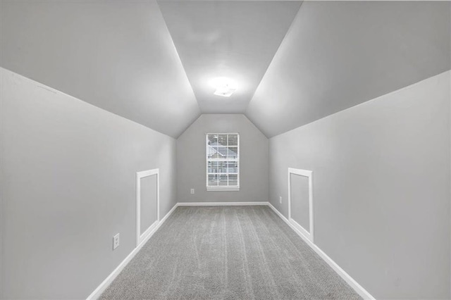 additional living space with vaulted ceiling and carpet flooring