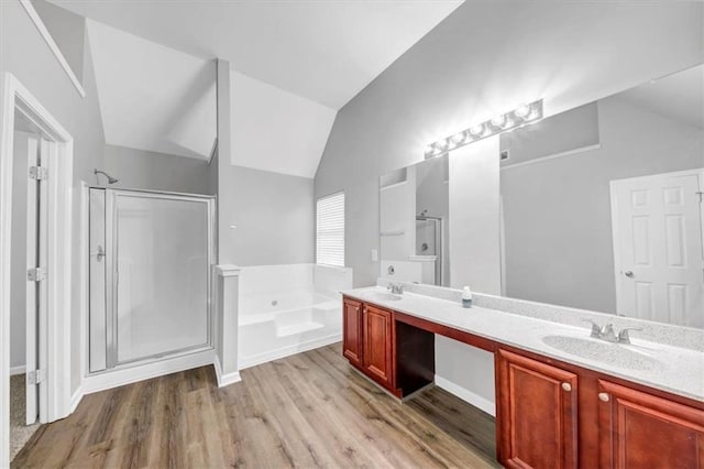 bathroom featuring vanity, vaulted ceiling, hardwood / wood-style flooring, and separate shower and tub