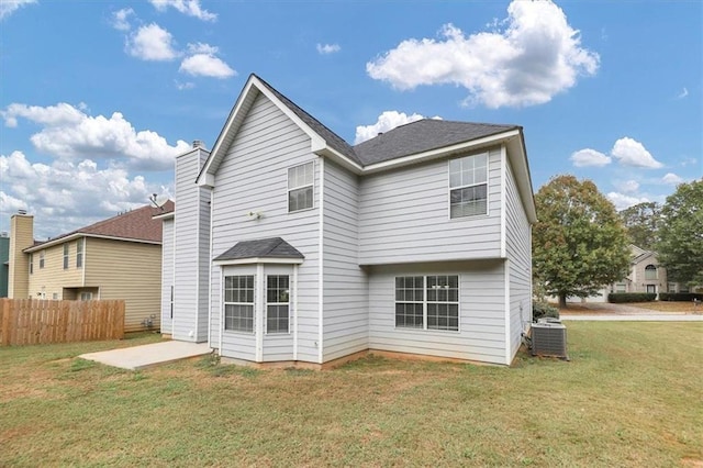 rear view of house featuring central air condition unit, a lawn, and a patio