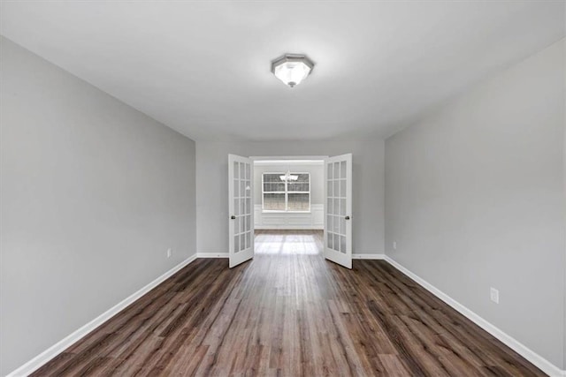 empty room featuring french doors and dark wood-type flooring