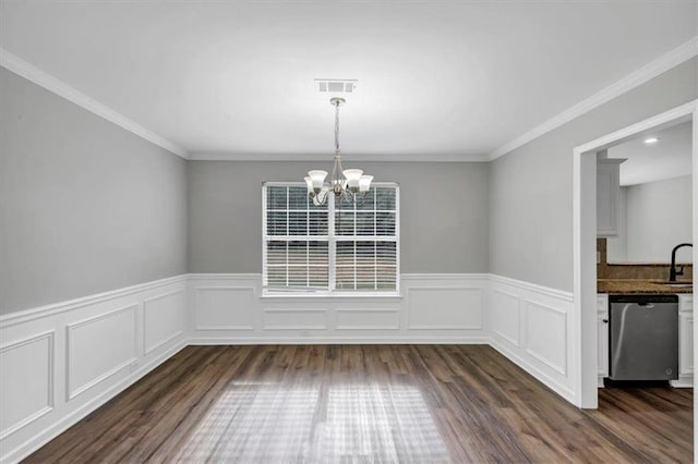 unfurnished dining area with dark wood-type flooring, sink, a notable chandelier, and ornamental molding