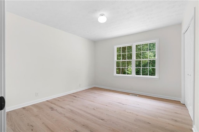6273 Oak Ridge Dr, Flowery Branch, GA 30542 - unfurnished bedroom featuring light wood finished floors, baseboards, a closet, and a textured ceiling