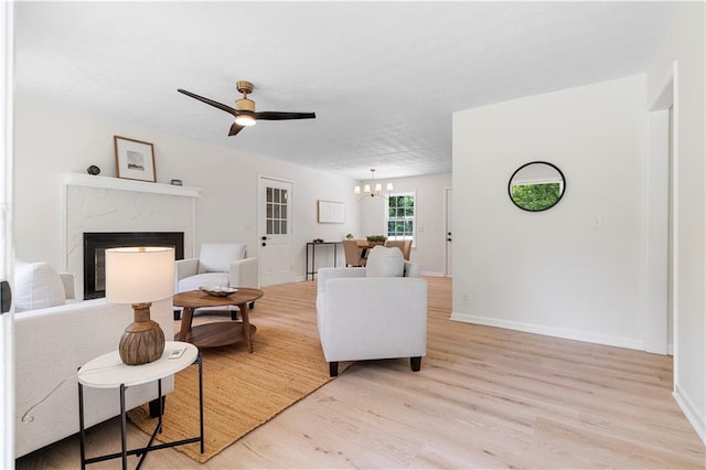 6273 Oak Ridge Dr, Flowery Branch, GA 30542 - living area with light wood-style flooring, a high end fireplace, a chandelier, ceiling fan, and baseboards