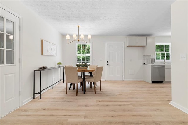 6273 Oak Ridge Dr, Flowery Branch, GA 30542 - dining area featuring plenty of natural light, light wood-style flooring, a chandelier, a textured ceiling, and baseboards