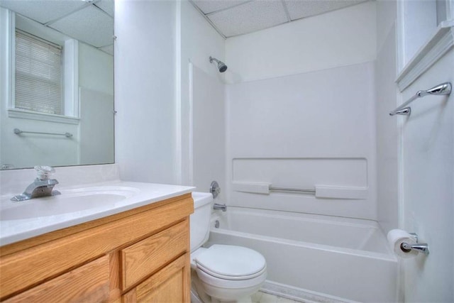 full bathroom featuring a drop ceiling,  shower combination, toilet, and vanity