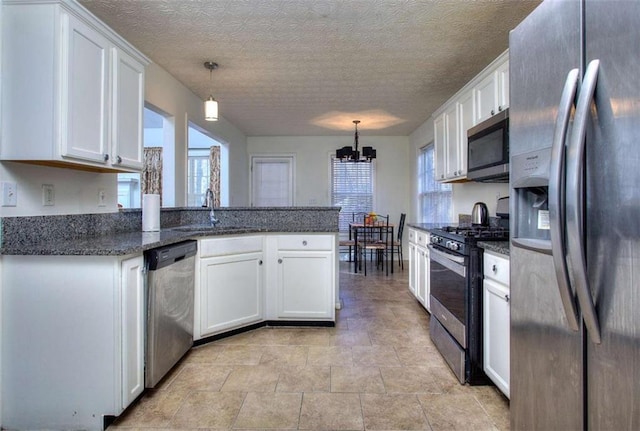 kitchen with pendant lighting, sink, white cabinets, and stainless steel appliances