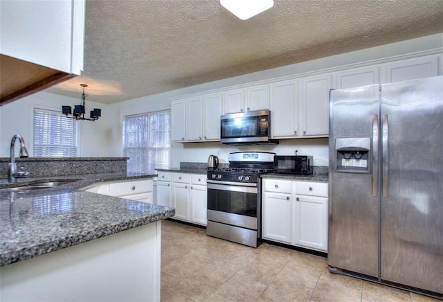 kitchen featuring sink, white cabinets, stainless steel appliances, and a notable chandelier