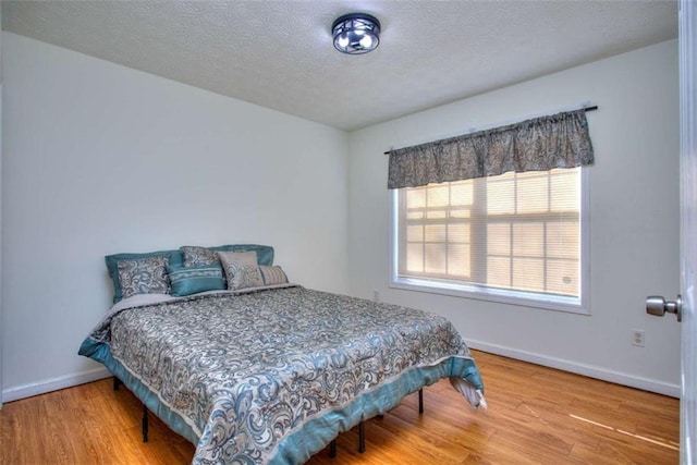 bedroom featuring wood-type flooring and a textured ceiling