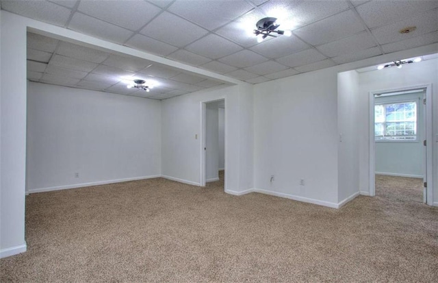 carpeted spare room with a drop ceiling