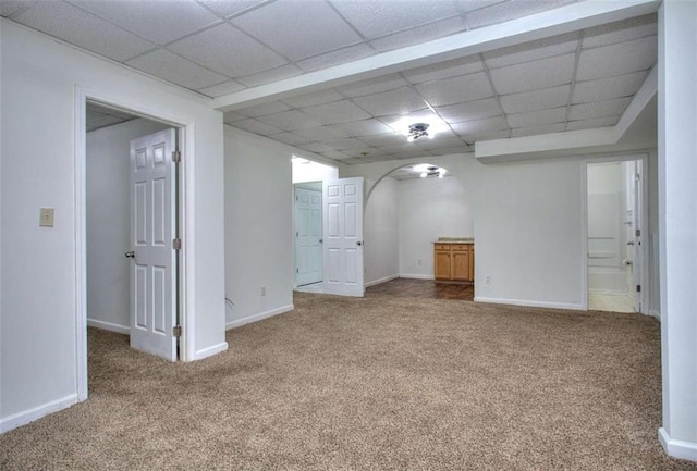 basement with a paneled ceiling and carpet flooring