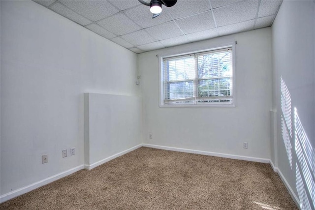 unfurnished room with a paneled ceiling and carpet floors