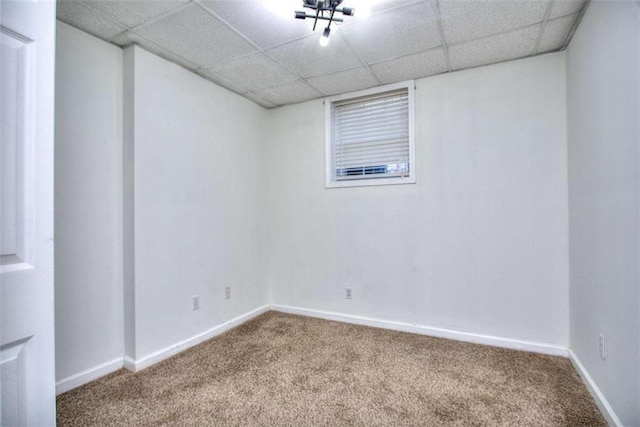 empty room with carpet flooring and a paneled ceiling