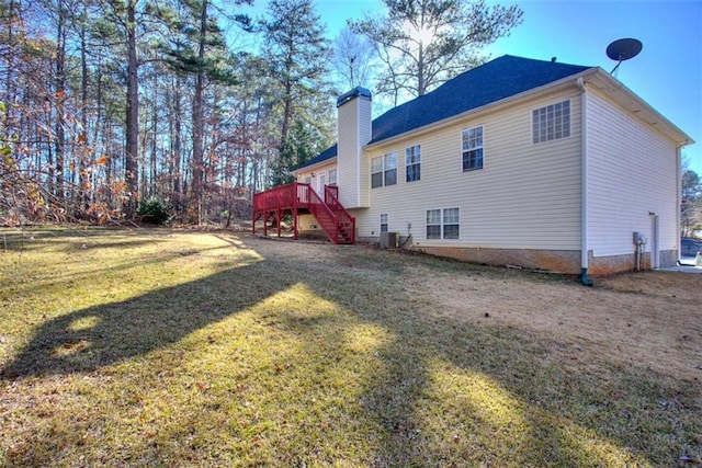 exterior space with a yard, a deck, and central AC unit