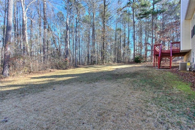 view of yard featuring a wooden deck and central AC