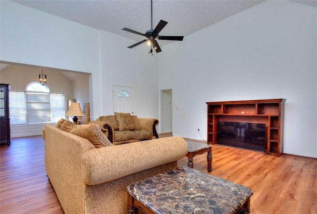 living room featuring hardwood / wood-style floors, ceiling fan, and high vaulted ceiling