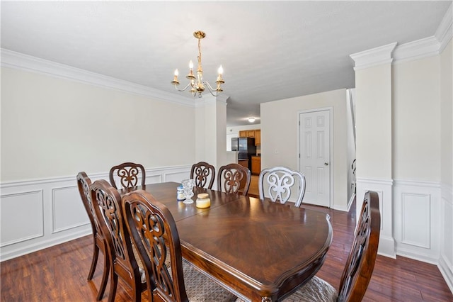 dining room featuring a notable chandelier, ornamental molding, and dark hardwood / wood-style floors