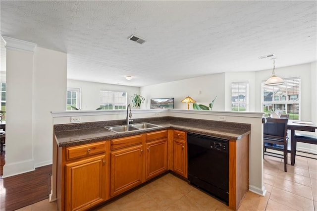 kitchen with light tile patterned floors, black dishwasher, sink, and plenty of natural light