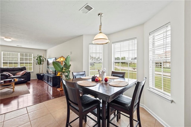 dining space with light tile patterned flooring and a healthy amount of sunlight