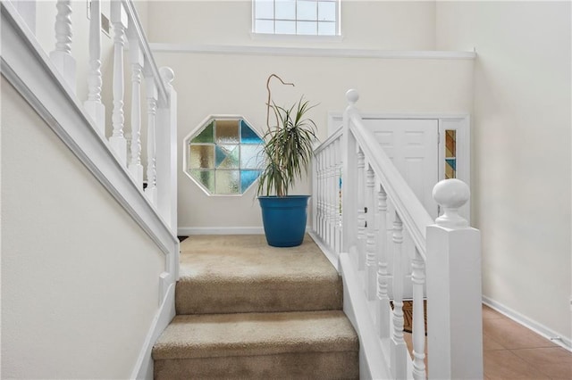 staircase featuring tile patterned flooring and a healthy amount of sunlight