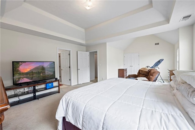 bedroom featuring a tray ceiling, a closet, and light carpet