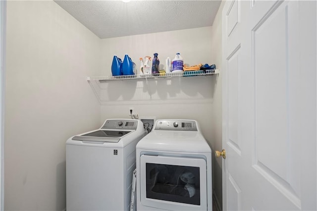 laundry room with a textured ceiling and washer and dryer