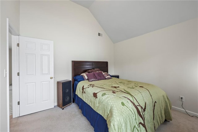 carpeted bedroom with high vaulted ceiling