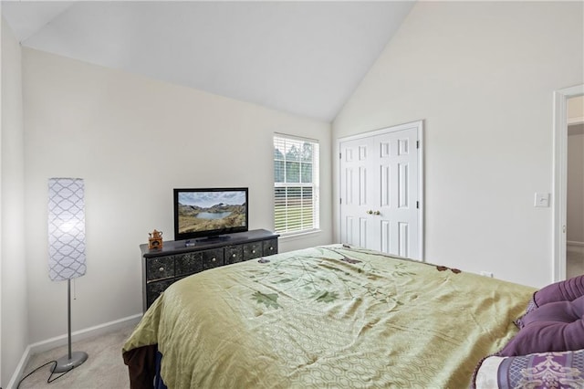 bedroom featuring high vaulted ceiling, a closet, and carpet flooring