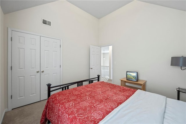 carpeted bedroom featuring a closet and high vaulted ceiling