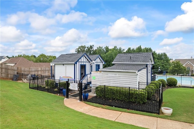 view of front of house with a front lawn and an outbuilding