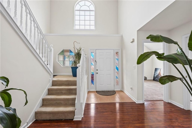 foyer entrance with a high ceiling and carpet floors