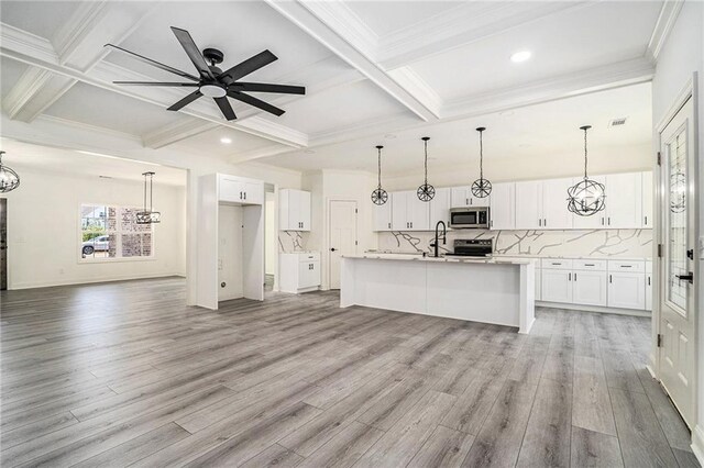 kitchen featuring appliances with stainless steel finishes, light hardwood / wood-style floors, white cabinetry, and an island with sink