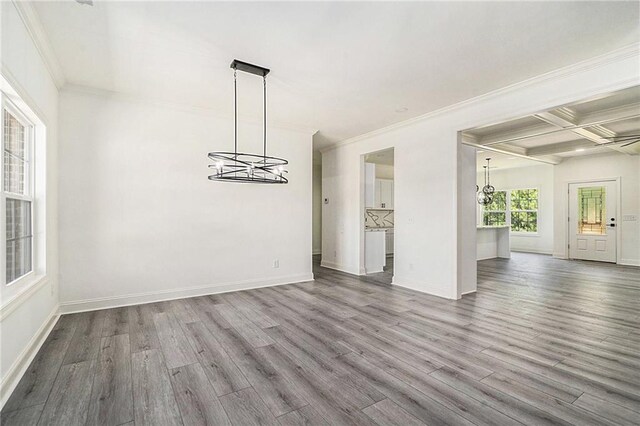 unfurnished dining area featuring beamed ceiling, wood-type flooring, ornamental molding, and coffered ceiling