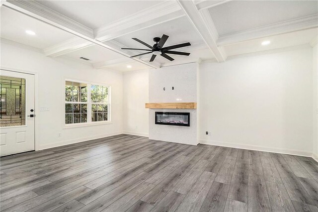 unfurnished living room featuring beam ceiling, ceiling fan, a large fireplace, and wood-type flooring