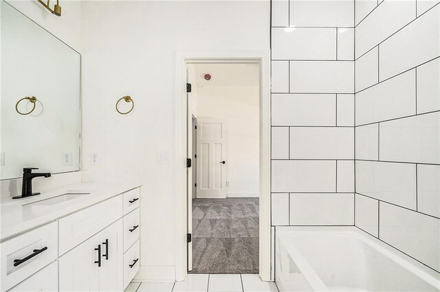 bathroom with tile patterned floors, a washtub, and vanity