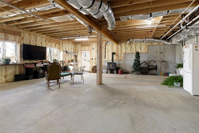 basement featuring white fridge and a wood stove