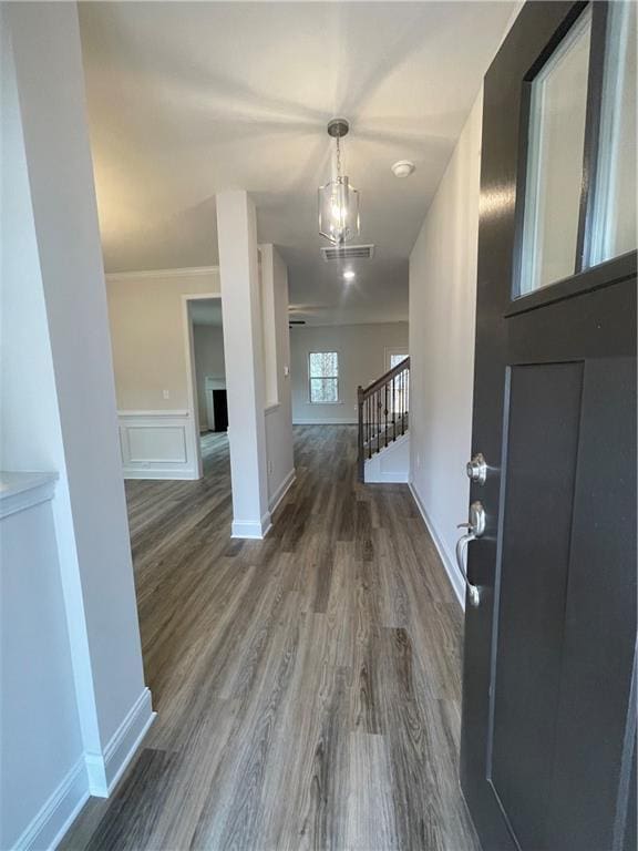 foyer entrance featuring dark wood-style floors, visible vents, a decorative wall, wainscoting, and stairs